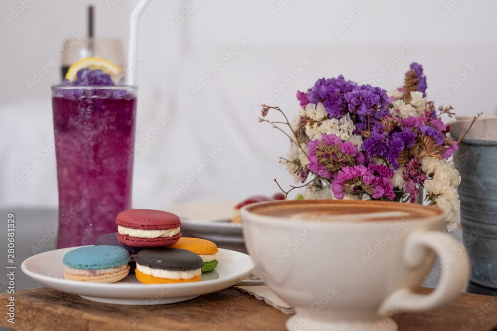Butterfly pea water and macaron and hot coffee mug in the front Butterfly pea water and macaron and hot coffee mug in the front
