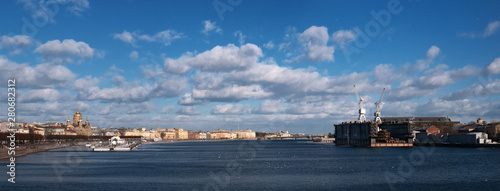 Panorama of the Neva from the side of the icebreaker Krasin. It is a ship-museum. On the other side there is a floating dock for repairing ships. Left - Assumption Cathedral