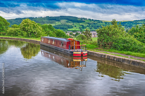 Schilderij op canvas Narrowboat moored on a British canal in rural setting