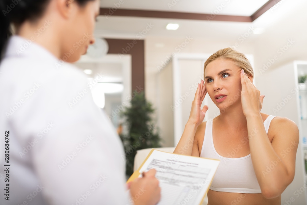 Woman talking with her cosmetologist about rejuvenation procedures. Woman talking with her cosmetologist about rejuvenation procedures.