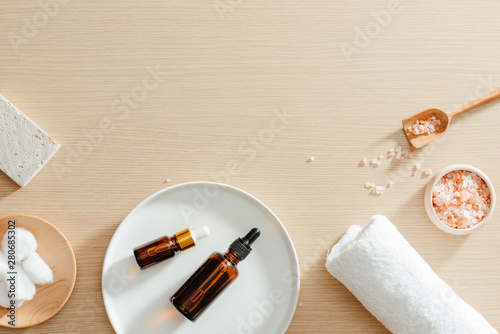 Spa still life top view with flowers, natural oil, bath salth and towels, spa skincare products,pumice stone photo