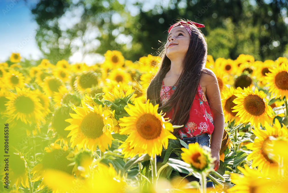 Child girl in yellow garden of sunflowers Child girl in yellow garden of sunflowers