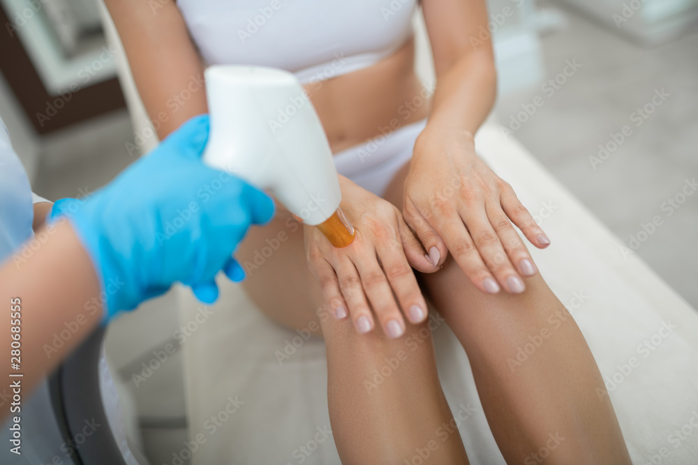 Fototapeta premium Hands of a woman during laser procedures.