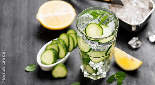 Healthy fresh cucumber lemonade with lemon and ice cubes.