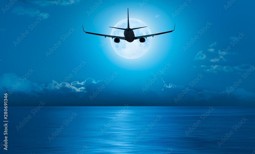 Naklejka premium Passenger airplane in the sky against blue full moon 