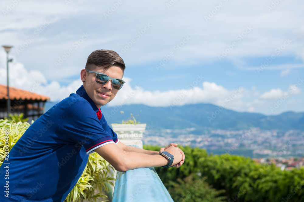 Young guy portrait outdoors with landscape at the background