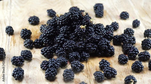 Wallpaper Mural Close-up blackberries rotating on wooden table. 4K Torontodigital.ca