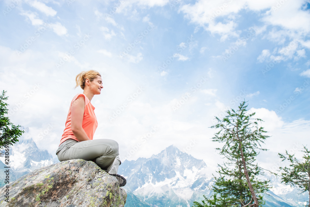 Beautiful young woman meditating in the mountains Beautiful young woman meditating in the mountains