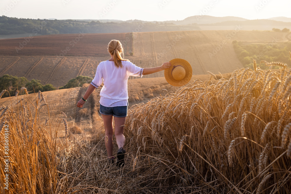 Happy woman enjoying summer at countryside during sunset