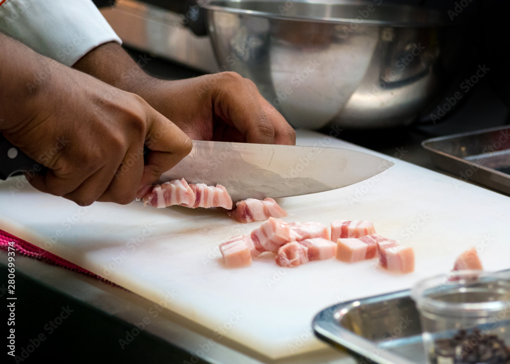 chef slice pork  belly and cutting in kitchen restaurant, Streaky pork or pork belly