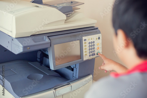 Selective focus to men press the button on panel of the copier and scanner. Business man using all in one machine, printer, scanner and copier. Working in office concept.