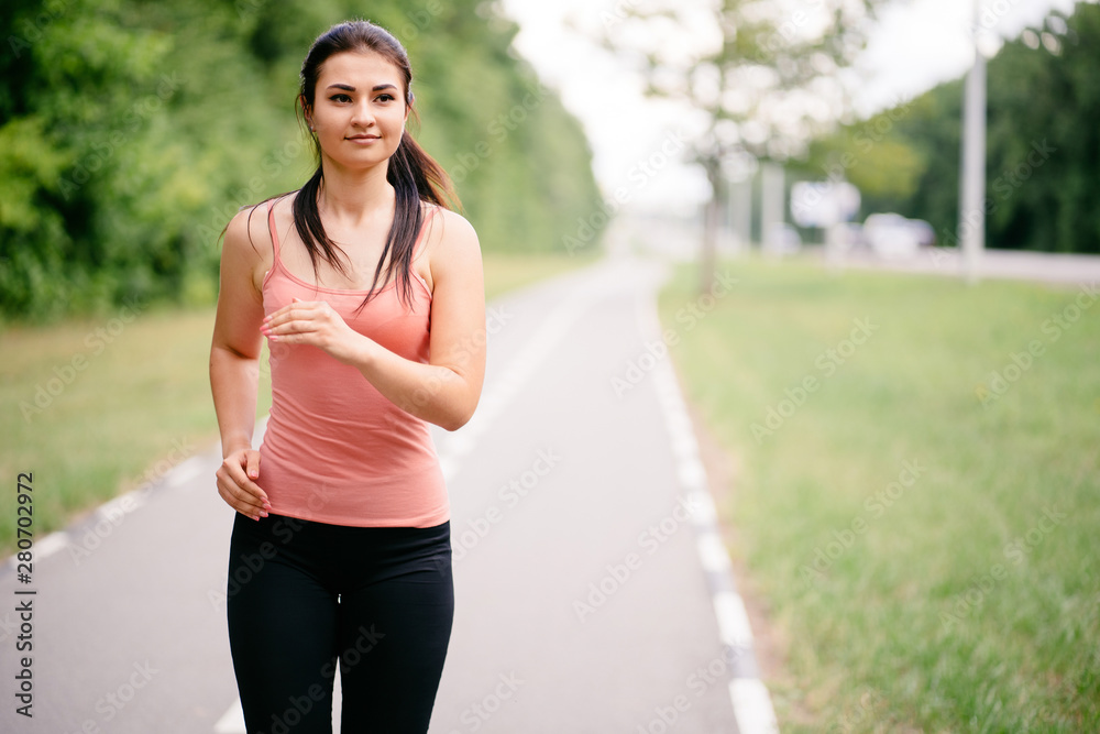 Sport, fitness, healthy lifestyle, cardio training. Active woman with athletic body running in the park. Smiling female jogger working out outdoor Sport, fitness, healthy lifestyle, cardio training. Active woman with athletic body running in the park. Smiling female jogger working out outdoor