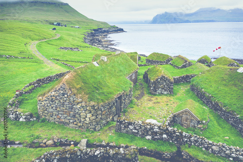 Aerial view of fishing village in Koltur island. Faroe Islands. Green roof houses. Photo made by drone from above. Nordic natural landscape. photo