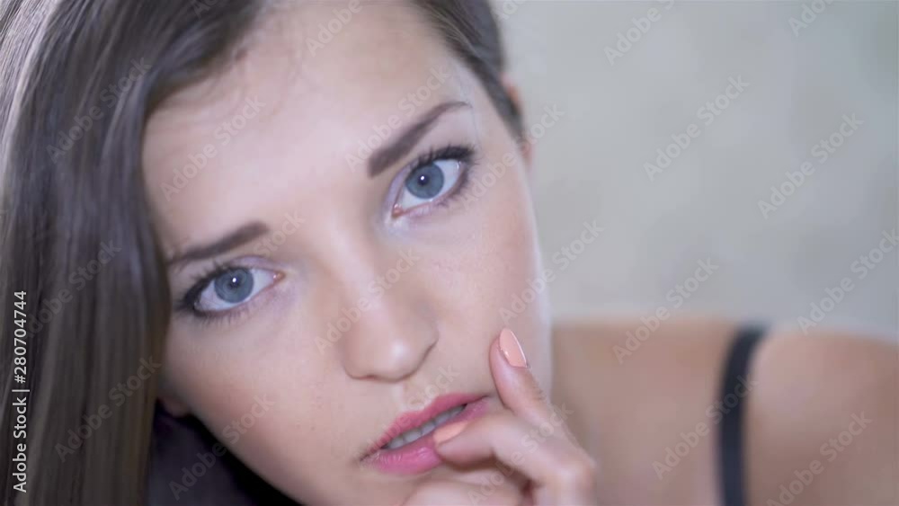4K. Young sexy seductive woman model lies on bed, looking on camera, face close up 4K. Young sexy seductive woman model lies on bed, looking on camera, face close up