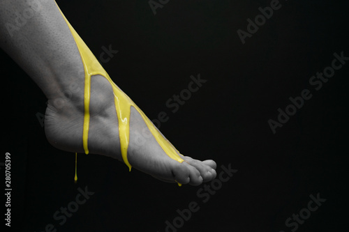 Yellow acrylic painting on woman foot