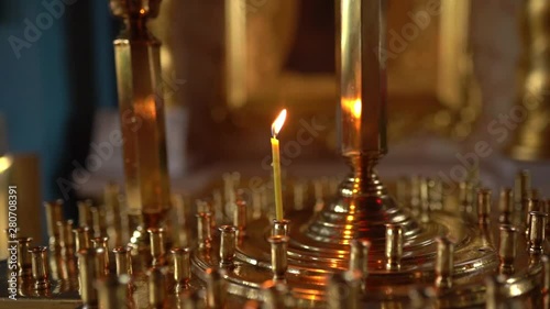 Inside the church, orthodox cathedral interior, religion concept. Ukrainian religion. Slow-motion video, candle fire sticks.