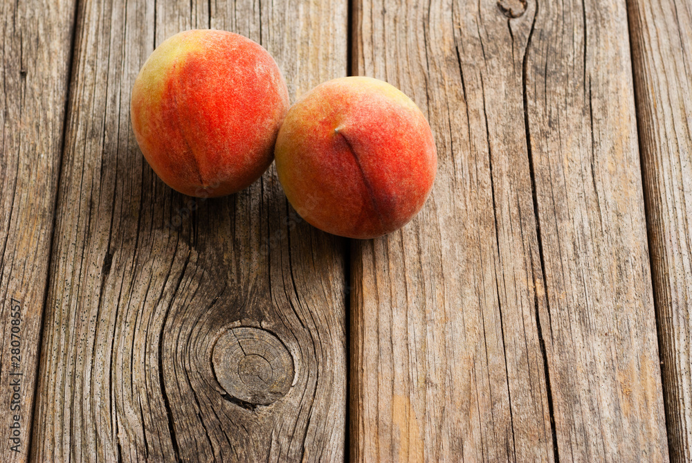 two peach fruits on old weathered wooden table background two peach fruits on old weathered wooden table background
