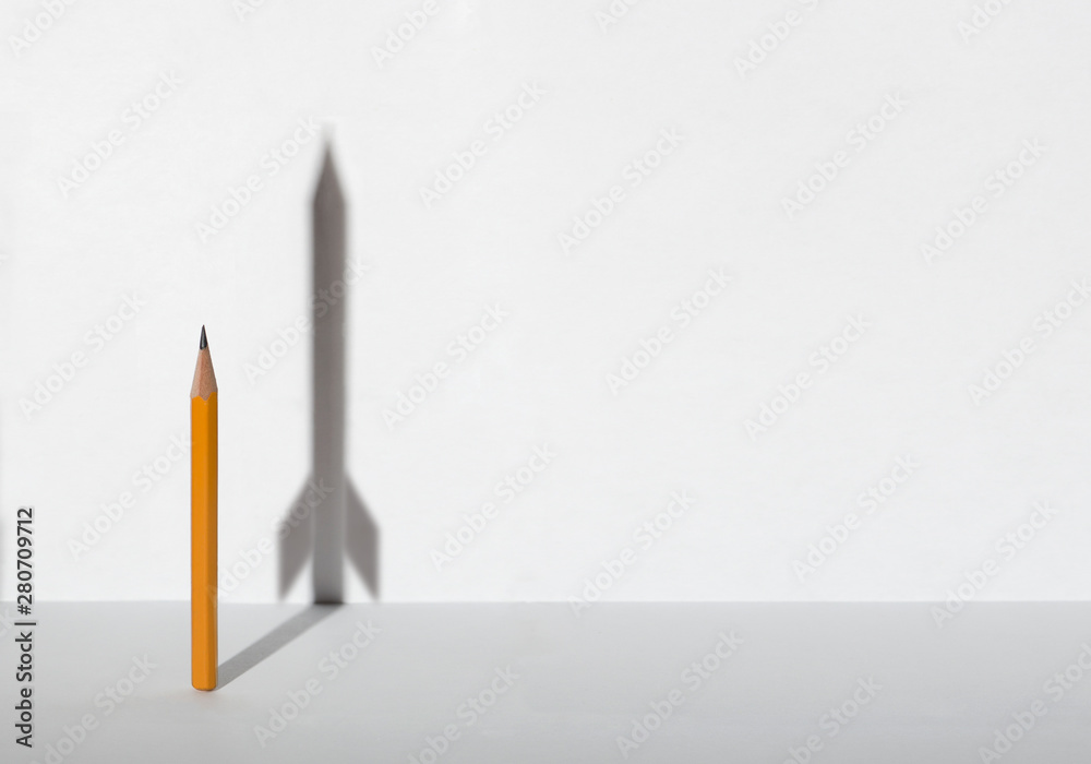 Pencils and a shadow in form of spacecraft . Success, cureer and