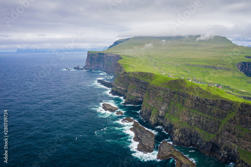 Aerial view of Mykines island in Faroe Islands, North Atlantic Ocean. Photo made by drone from above. Nordic natural landscape.
