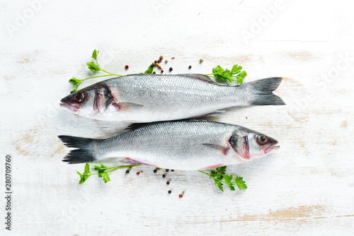 fish seabass with spices. Seafood on a white wooden background. Top view. Free copy space.