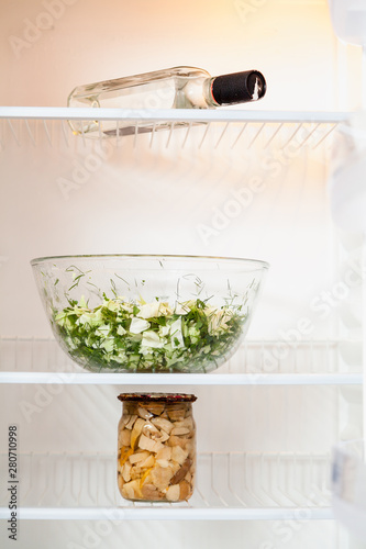 In empty fridge there is salad, mushrooms and vodka