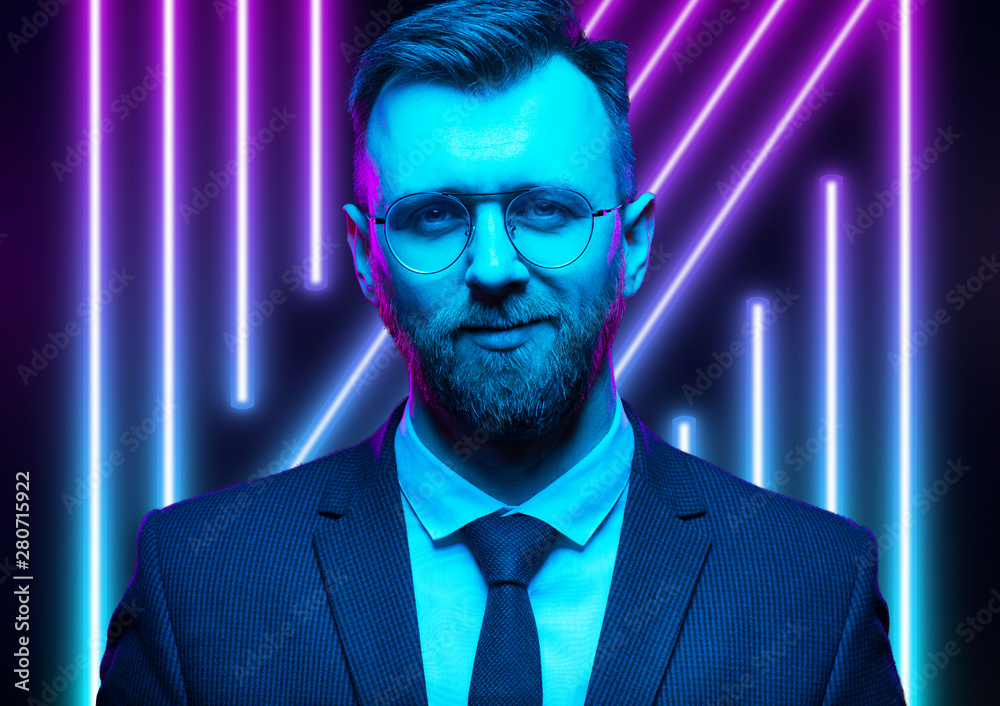 Young handsome model posing in a studio in a trendy neon light. Fashionable man in a stylish suit. Vibrant color. Bright colorful light effects. Disco style. Overlay. Gel filter. Supersaturated Young handsome model posing in a studio in a trendy neon light. Fashionable man in a stylish suit. Vibrant color. Bright colorful light effects. Disco style. Overlay. Gel filter. Supersaturated