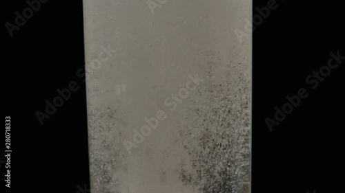 Glass of water with aspirin white tab. Sparkling Bubbles in glass of water.  Effervescent tablet falls on a bottom of a glass