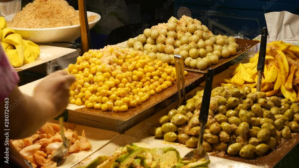 People buy variation of pickled fruits, Thailand. They are consumed as a type of snack in Thai culture. Many of them taste sour and sweet.