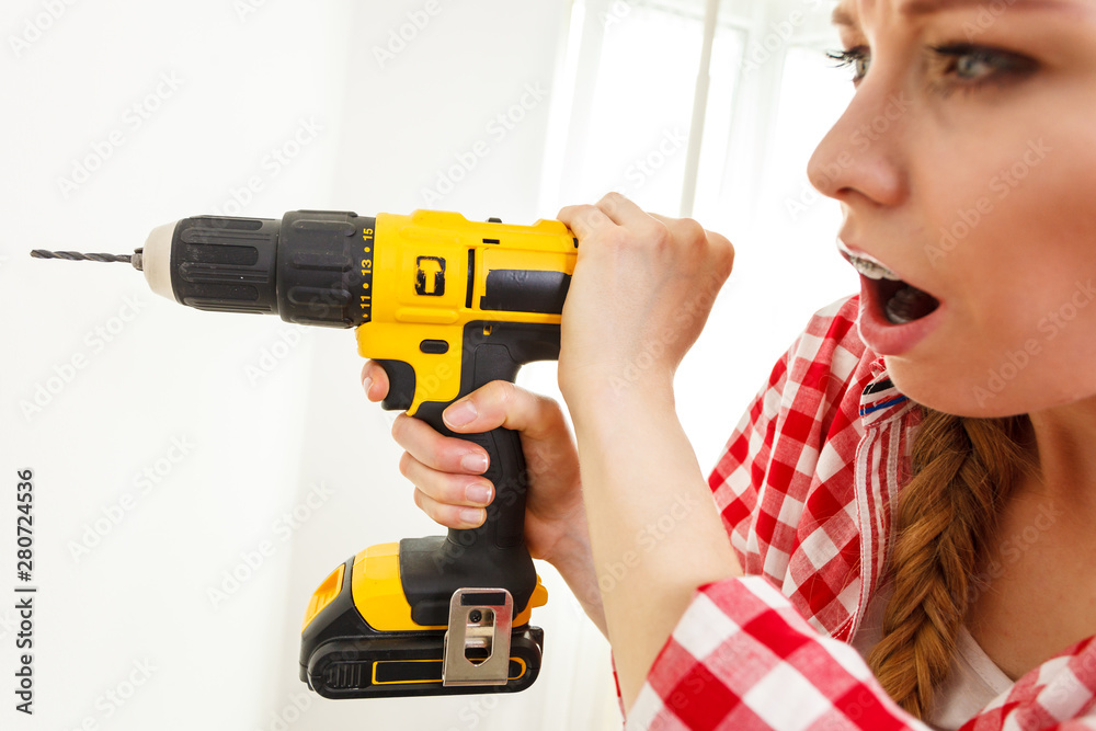 Woman having troubles using drill