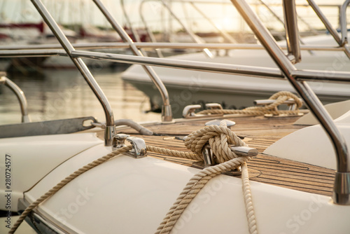 White mooring rope tied around steel anchor on boat