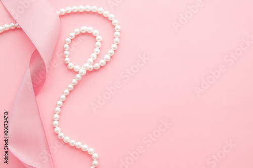 Valokuva Feminine desktop mockup with pearls and pink ribbon on pink background