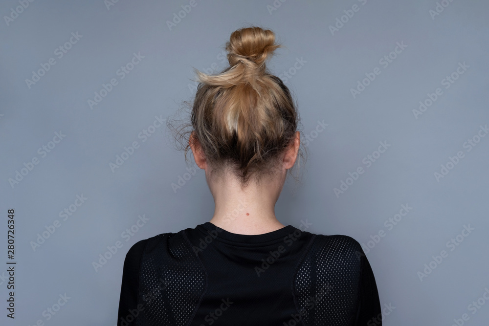 Young girl simple hairstyle back view. Fashionable and simple hairdresser  work. Fashion model, trendy woman. Blonde long hair in top bun close-up  photo. Elegant and everyday look for girls Stock Photo |