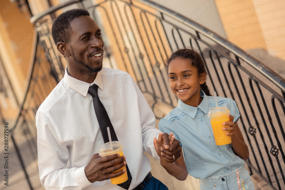 Obraz premium Handsome man walking hand in hand with his kid