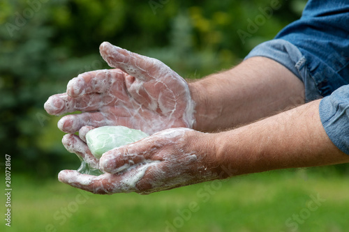 Hand washing with soap outdoors.