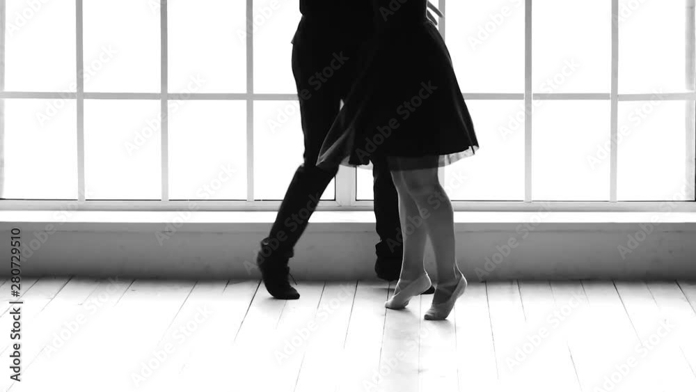 Slow motion two dancers working out in ballet studio. Low section man and woman dancing together. Black and white. Slow motion two dancers working out in ballet studio. Low section man and woman dancing together. Black and white.