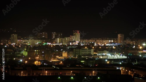 Wallpaper Mural Night city skyline timelapse. Top aerial panoramic view of modern city from tower rooftop. Road junction traffic. Lights flicker in windows. Residential flats,factory pipes with smoke Torontodigital.ca