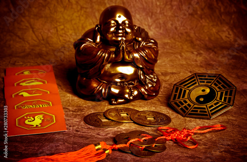 Photo Oriental belief with happy Buddha, coins of good luck, yin yang and chinese zodi