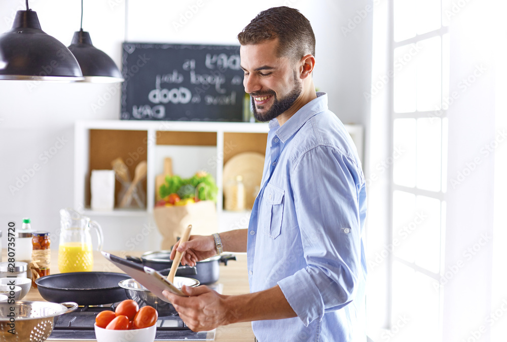 Smiling and confident chef standing in large kitchen Smiling and confident chef standing in large kitchen