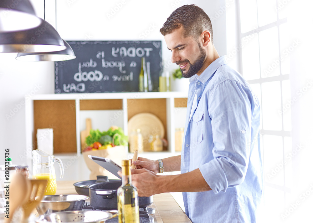 Smiling and confident chef standing in large kitchen Smiling and confident chef standing in large kitchen