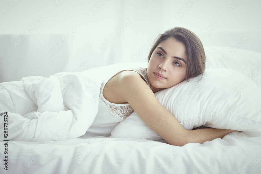 beautiful young woman basking in bed in the morning. Beautiful