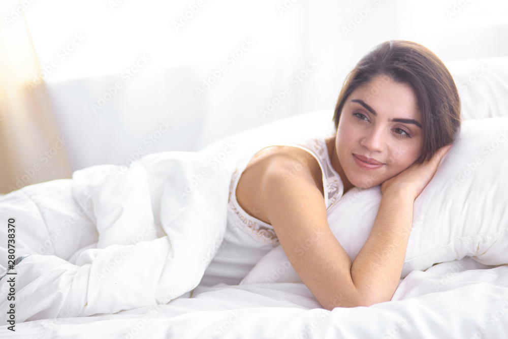 beautiful young woman basking in bed in the morning. Beautiful beautiful young woman basking in bed in the morning. Beautiful