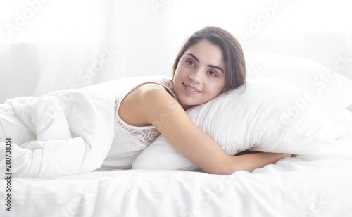 beautiful young woman basking in bed in the morning. Beautiful