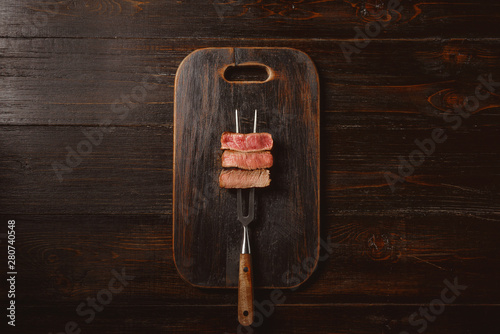 Three pieces of meat on a fork for meat. three types of meat roasting, rare, medium,well done.
