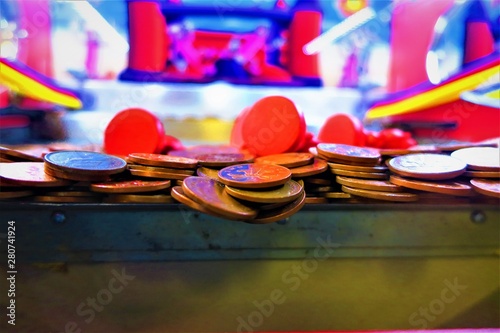 Anticipation: Two pence coins teeter on the edge inside a coin pusher machine photo