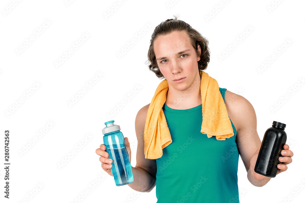 Handsome young man in sport shirt holding bottle of water and supplements. White background isolated Handsome young man in sport shirt holding bottle of water and supplements. White background isolated