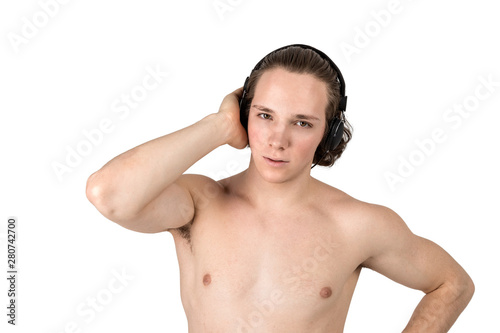 Handsome naked young man in towel listening to music in headphones on white background isolated