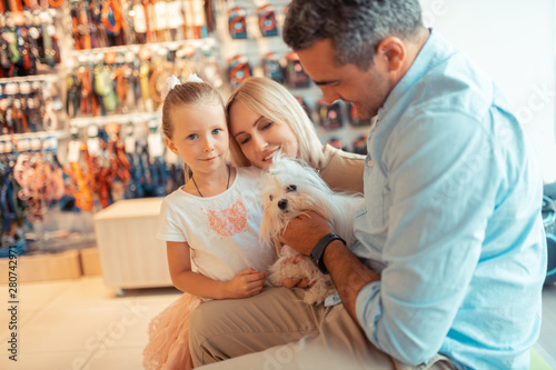 Fotografie Girl feeling happy coming to pet shop with mom and dad