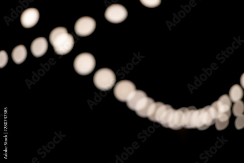 White round chains of garlands on a black background. Blurred photo. Festive background.
