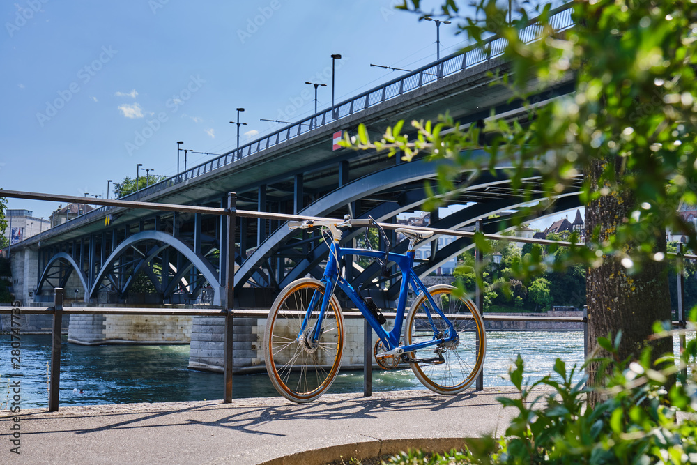 Bicycle Parked On Road By River Against Bridge In City During Sunny Day