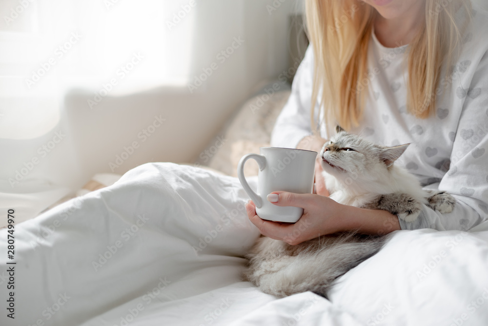 Good morning concept blonde girl with the cat and coffee cup hygge lagom concept. Horizontal copyspace
